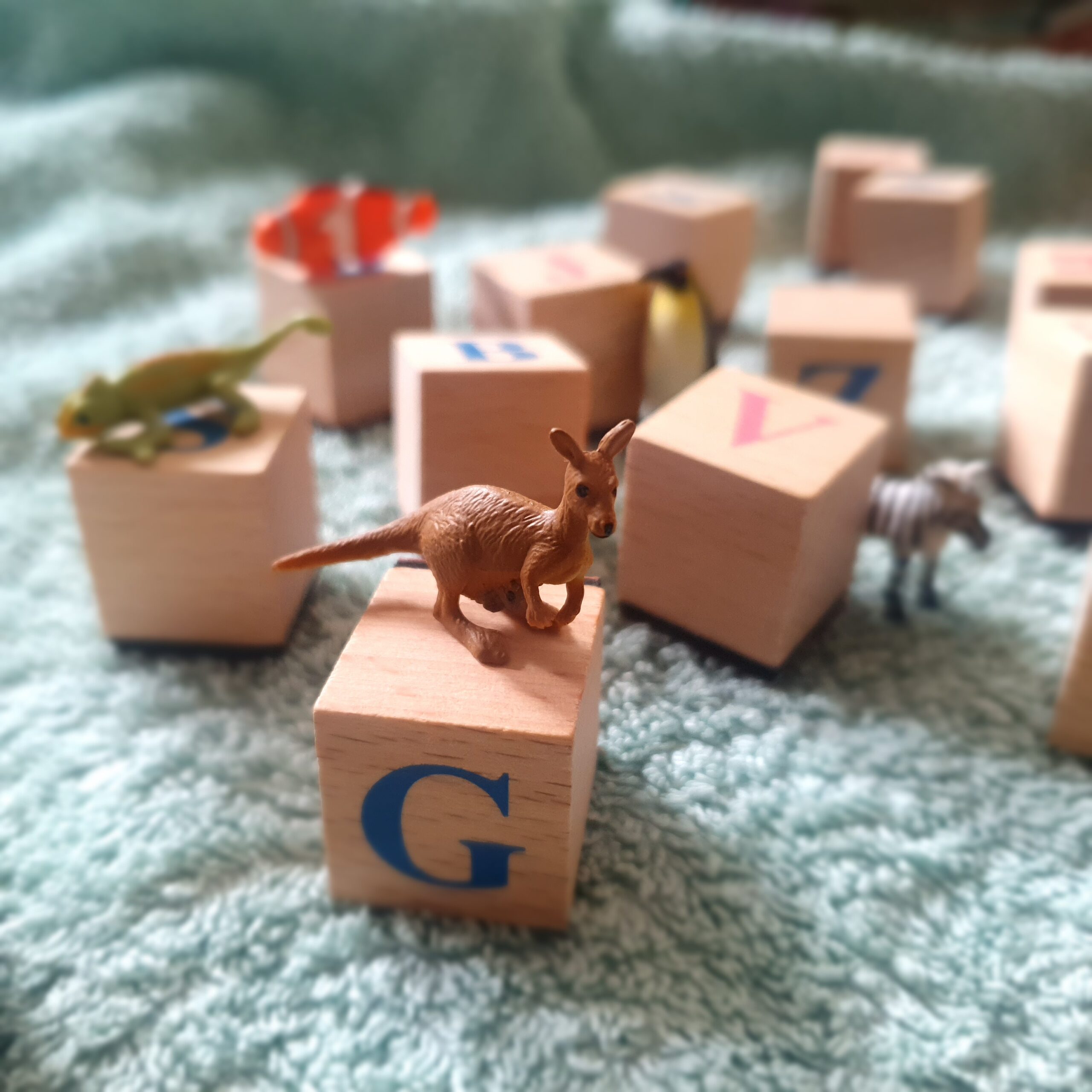 auf eine hellen Decke liegen Holzwürfel mit kleinen Spielfiguren darauf und daneben.